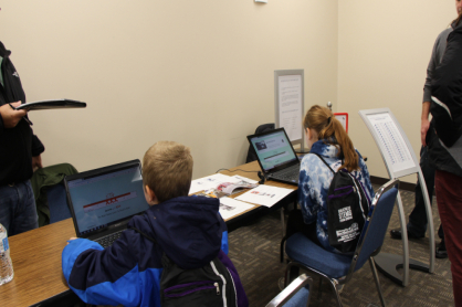 Students playing on a computer to learn about measuring.